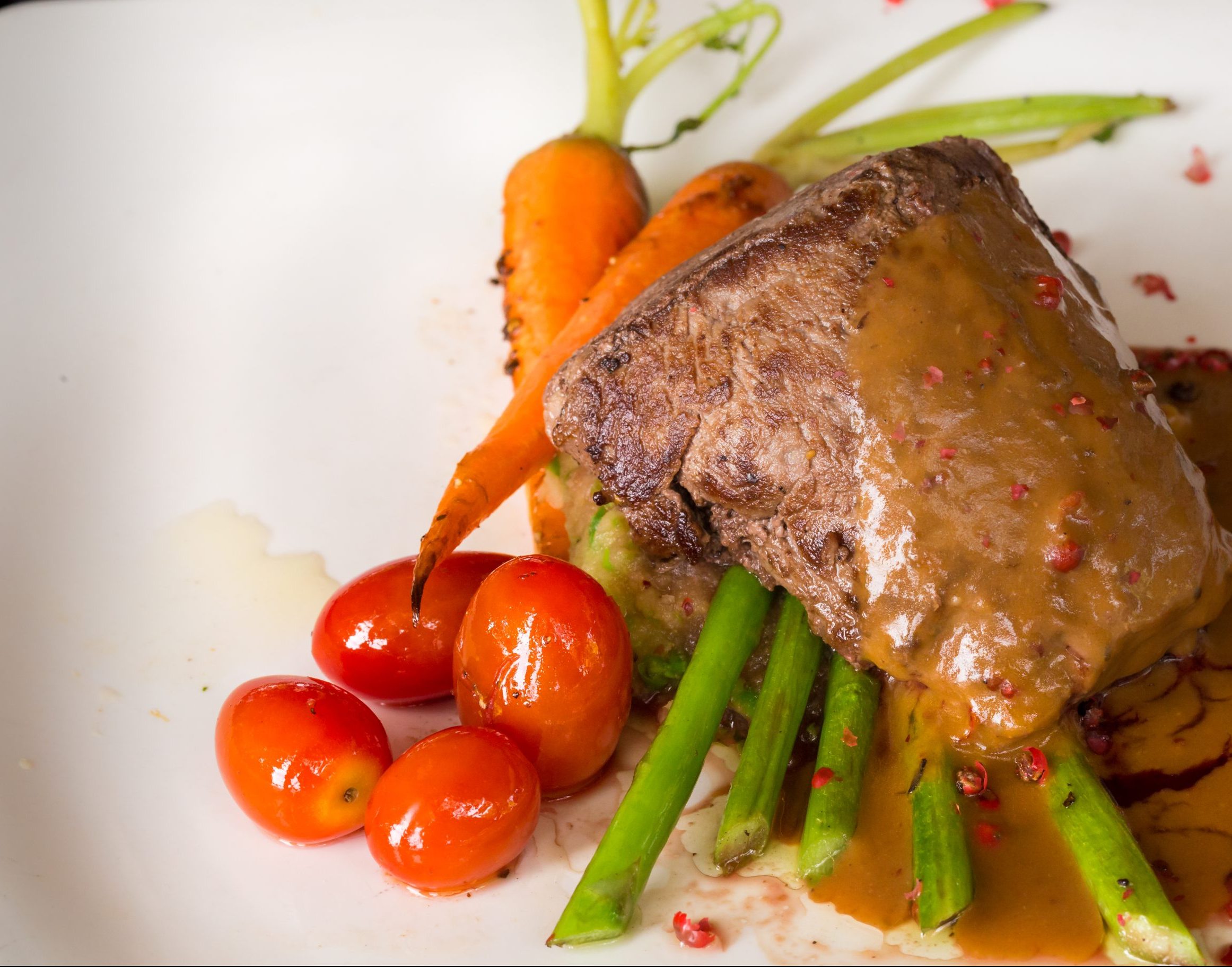 Grilled beef tenderloin with asparagus and tomato in red wine sa